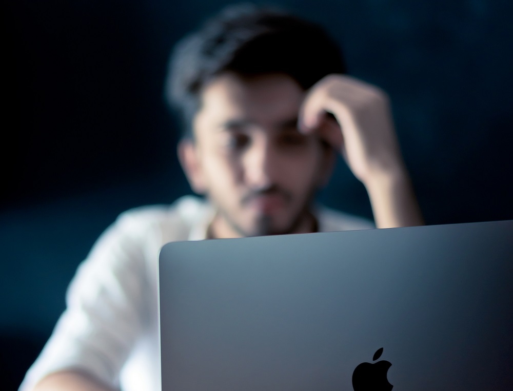 a man looking at a mac screen