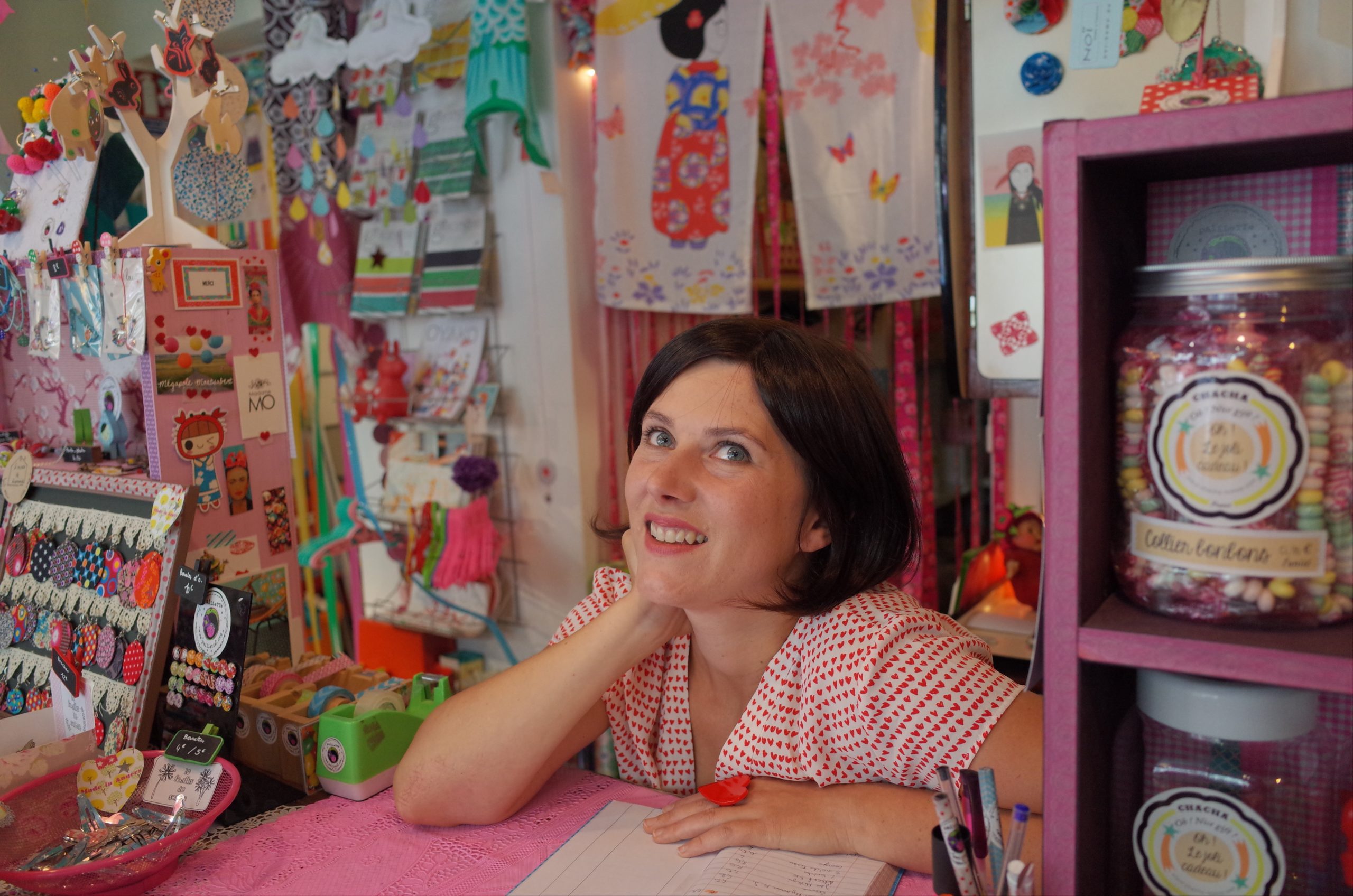 An amazon storefronts business owner posing inside her shop full of displayed knick knack merchandise