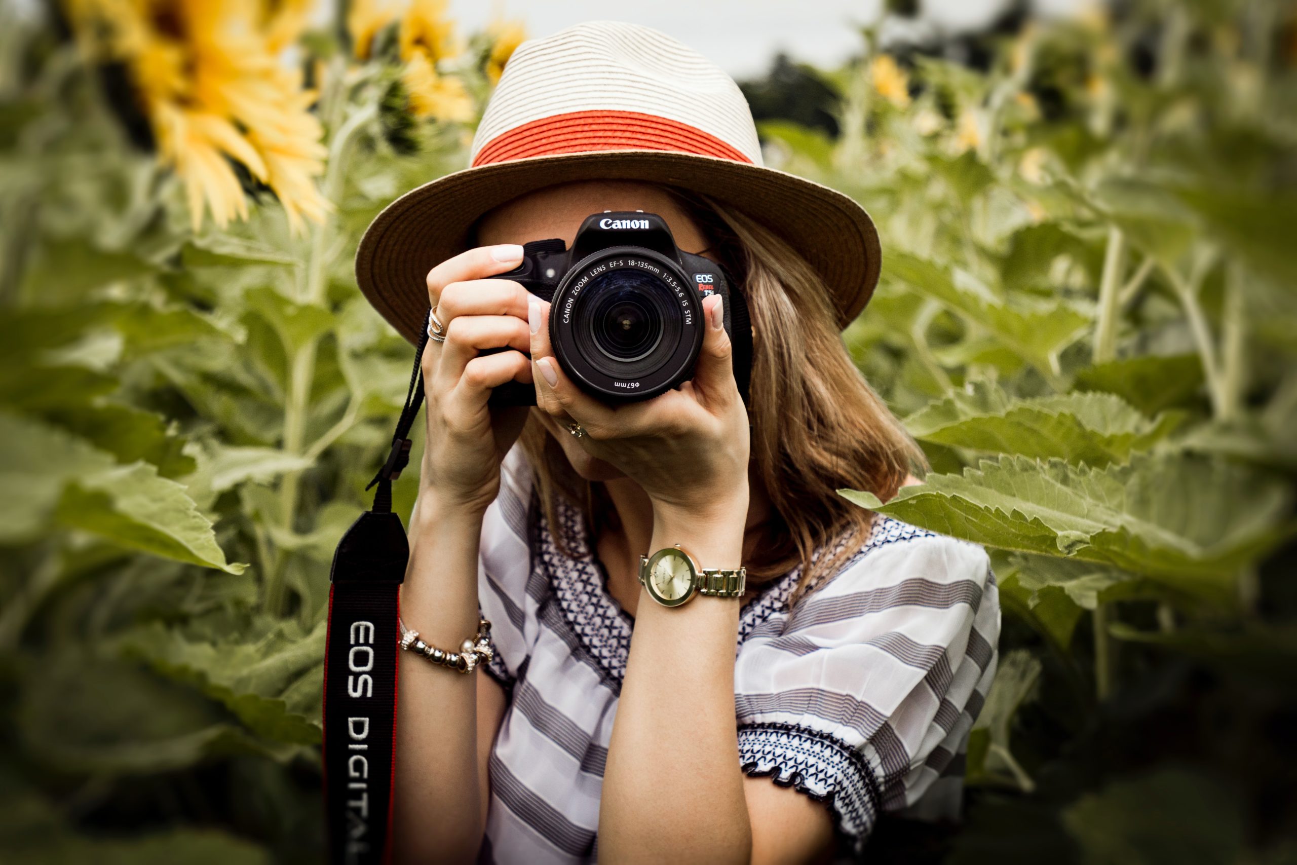 a female photographer ready to take a picture as she holds a camera against her face