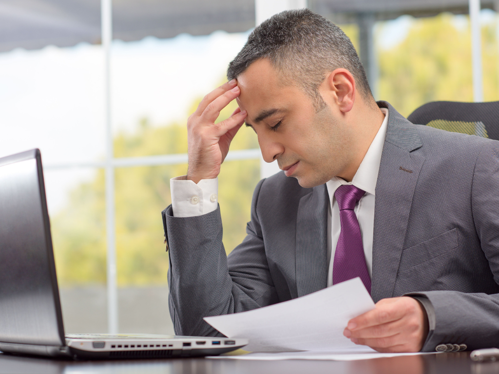 Businessman with a headache after hiring a developer