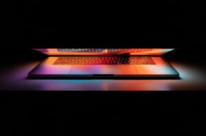 partially open lit up laptop on table